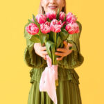 دختر جوان با دسته گل لاله صورتی