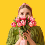 دختر جوان با دسته گل لاله صورتی