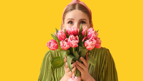 دختر جوان با دسته گل لاله صورتی