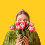 دختر جوان با دسته گل لاله صورتی